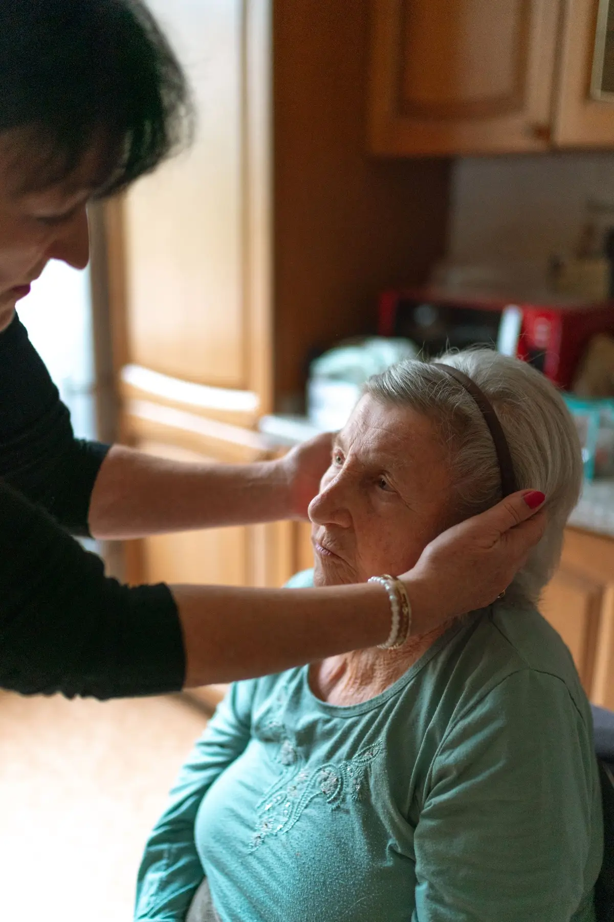 Caregiver helping an older woman at home (How to Help an Elderly Parent Bathe Safely and With Dignity)